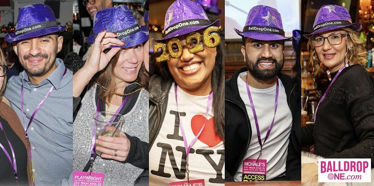 Five smiling adults wearing purple sequined hats with 'BallDropOne.com' band, standing in a festive indoor setting; one person wears gold glitter 2026 glasses and another a white shirt with 'I ♥ NY' print, all with purple lanyards, holding drinks or posing.